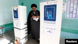 Shi'ite cleric Muqtada al-Sadr casts his vote at a polling station in Baghdad during parliamentary elections on April 30.
