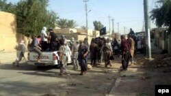 Militant Iraqi Sunni gunmen are seen on a street in the northern city of Tikrit on June 11.