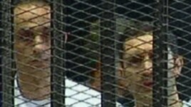 A TV grab shows Gamal (left) and Alaa Mubarak in a holding cell in the courtroom in the police academy on the outskirts of Cairo in August 2011.