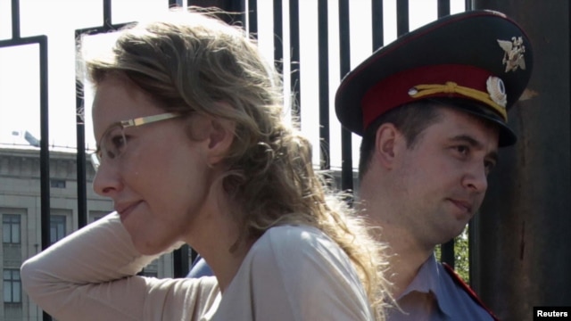 Russian opposition figure and TV host Ksenia Sobchak (left) arrives for questioning at the Russian Investigative Committee on June 15.