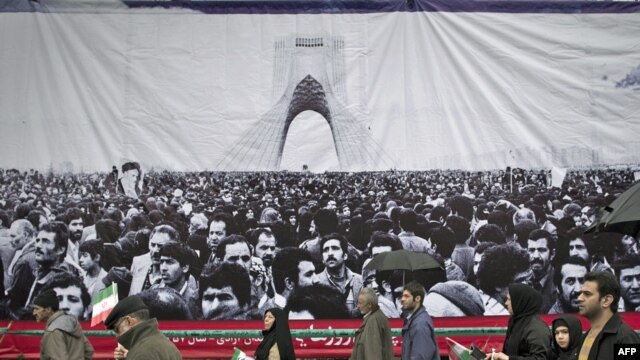  تظاهرکنندگان شرکت کننده در راهپيمايی ۲۲ بهمن از مقابل تصوير روزهای نخست انقلاب بهمن ۱۳۵۷ عبور می کنند.