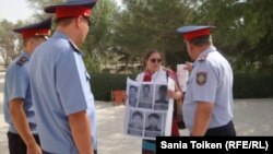 Құқық қорғаушы Әсел Нұрғазиева полициямен сөйлесіп тұр.