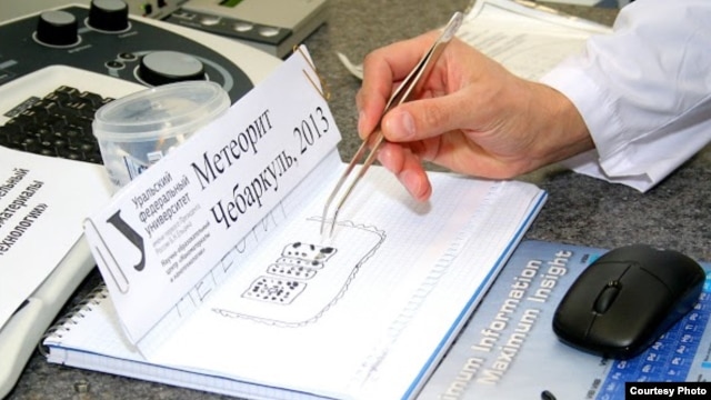 Aleksei Ischenko, head of lab scanning methods at Ural Federal University's Nanotechnologies and Nanomaterials center, inspects Chelyabinsk meteorite fragments and data.