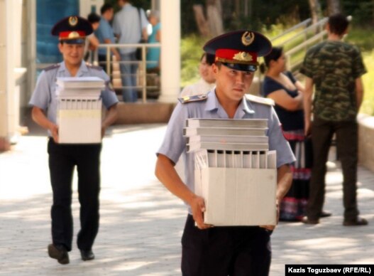 Полиция қызметкерлері сопылық ағым өкілдерінің үстінен қозғалған қылмыстық іс материалын сот залына әкеле жатыр. Алматы, 13 шілде 2011 жыл