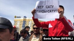 Жерді шетелдіктерге жалға беруге және сатуға қарсы жиында плакат ұстап тұрған азамат. Атырау, 24 сәуір 2016 жыл.