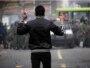 Iran -- a protester holds stones as he faces off against security forces in Tehran on 27dec2009