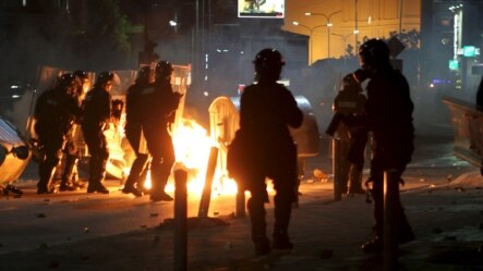 Police are seen next to a fire caused by a Molotov cocktail thrown by protesters during clashes in Pristina on October 12.