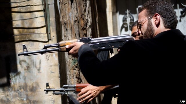 Members of the Free Syrian Army shoot at a nearby government army position in the Al-Jadeida neighbourhood of Aleppo.