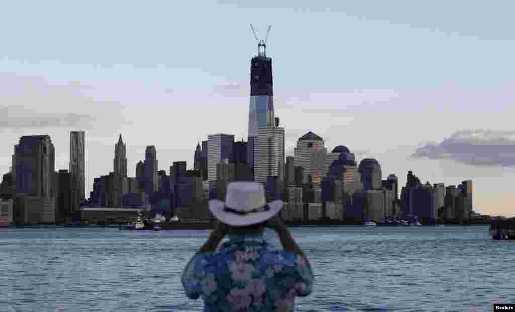 One World Trade Center stands tall on the skyline as a man takes a picture from in Hoboken, New Jersey, on September 9, 2012.