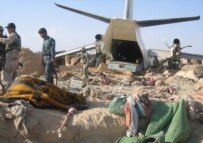 Afghan police and international troops inspect the crash site on April 24 (epa)