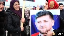 Chechen woman holds a picture of Ramzan Kadyrov during a rally in central Grozny earlier this year.