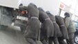 Сотрудники КУИС толкают машину с заключенными, которых везут в суд. Иллюстративное фото. 