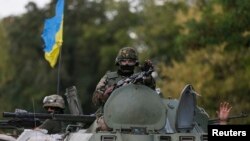 Ukrainian servicemen ride in an armored vehicle near Debaltseve, in the Donetsk region, on August 29.