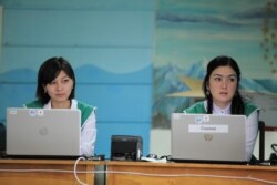Election workers stand by in Bishkek as voters cast their ballots using the new biometric ID system and automatic ballot boxes.