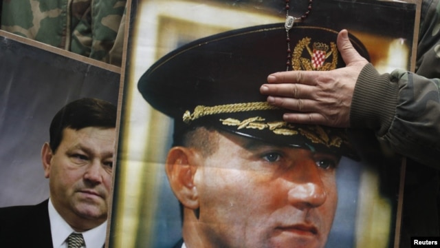Portraits of Ante Gotovina (foreground) and Mladen Markac are seen as people celebrate the court decision in Zagreb.