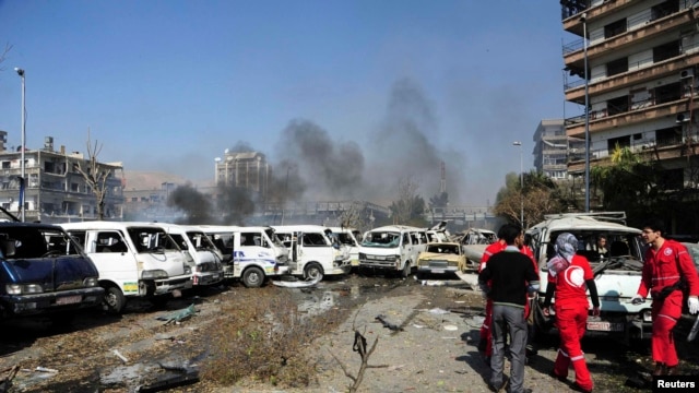Damaged vehicles and the Russian embassy building are seen after an explosion in central Damascus on February 21.