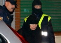 Masked members of Spanish security forces escort a veiled woman arrested early on 10 January 2006 (epa)