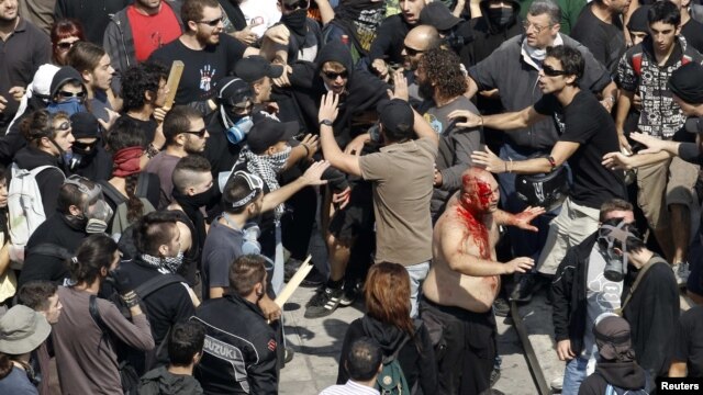 A man covered in his own blood tries to escape after a group of leftist protesters attacked him during a demonstration against austerity measures in Athens. (file photo)