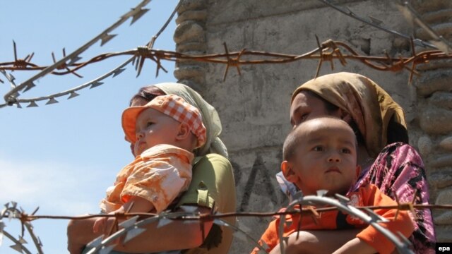 Ethnic Uzbek refugees stand at the Kyrgyz-Uzbek border crossing near Osh. Some 400,000 people have fled the violence. 