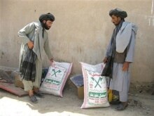 Afghanistan -- Afghan men recieve food rations from the World Food Program (WFP) during a distribution programme in Helmand province, 14May2007