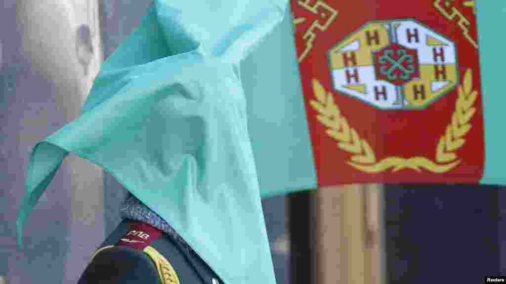 An honor guard's face is covered by Turkmenistan's national flag during an official ceremony welcoming Turkmen President Gurbanguly Berdymukhammedov in Kyiv, Ukraine, on March 13. (Reuters/Gleb Garanich)