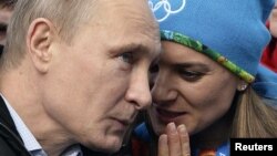 President Vladimir Putin speaks with Olympic Village Mayor and world-record pole vaultet Yelena Isinbayeva Sochi on February 5 ahead of the Winter Olympics.