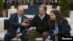 Russian President Vladimir Putin (left) and U.S. Olympic Committee Chairman Larry Probst (center) at USA House in the Olympic Village during the 2014 Sochi Winter Olympics on February 14