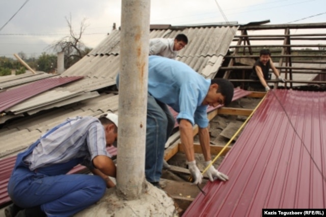 Civil society activists perform repairs on Atabek's home in September 2012.