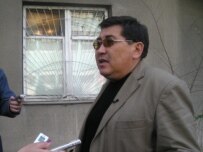 Editor Ermurat Bapi speaks to journalists after bullet holes were found in the window of \