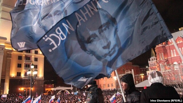 Supporters wave Putin banners on Manezh Square in Moscow soon after the polls closed on March 4, with election officials suggesting Vladimir Putin had enough votes to avoid a second-round runoff for the presidency.