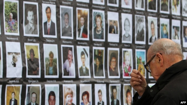A man crosses himself in front of the portraits of the hostage-drama victims at the Dubrovka Theatre in Moscow.