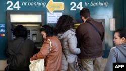 People withdraw money from an ATM in the Cypriot capital Nicosia. A proposed tax on savings has caused outrage in the island country.