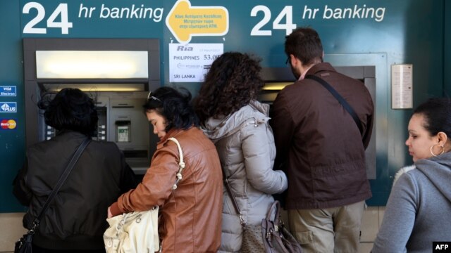 People withdraw money from an ATM in the Cypriot capital Nicosia. A proposed tax on savings has caused  outrage in the island country. 