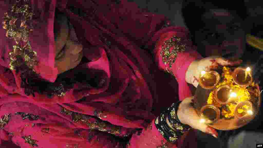 A Pakistani Hindu carries oil lamps on the occasion of Diwali in Lahore. Diwali, the festival of lights, is one of the biggest Hindu festivals. People decorate their homes with flowers and earthen lamps to celebrate the homecoming of the God Ram after vanquishing the demon king Ravana and honor the Hindu goddess of wealth, Lakshmi. (AFP/Arif Ali)