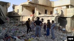 Men inspect the debris of houses after an apparent air strike by the Iraqi Air Force in Fallujah on September 1.