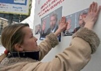 An activist sticks a poster of leading opposition candidate Alyaksandr Milinkevich onto a wall in Minsk (epa)