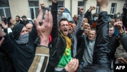 Pro-Russia militants, who had been detained during an attack on a Ukrainian unity rally on May 2, react after being freed following the storming of a police station in Odesa on May 4.