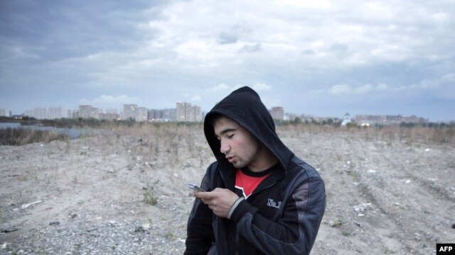 A Tajik migrant worker in Russia texts a message home.