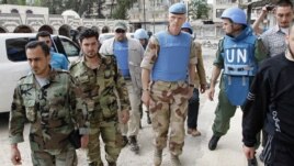 مراقبو الأمم المتحدة مع عناصر من الجيش السوري الحر في منطقة الخالدية بمدينة حمص. 