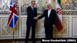 U.K. Foreign Secretary Philip Hammond (left) meets his Iranian counterpart Mohammad Javad Zarif in Tehran on August 23.