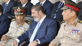 Egyptian President Muhammad Morsi (center) speaks with Hussein Tantawi (left) and Sami Anan during a ceremony in Cairo on July 17.