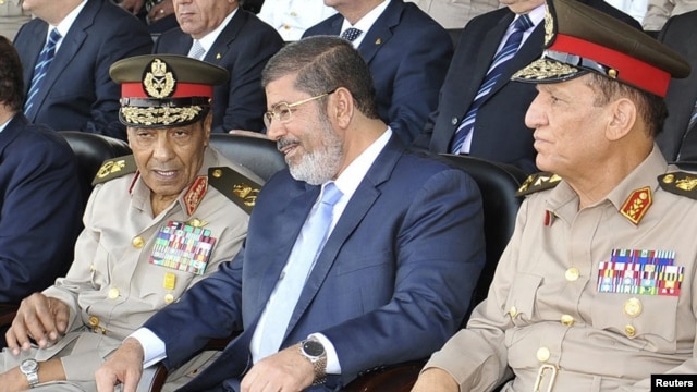 Egyptian President Muhammad Morsi (center) speaks with Hussein Tantawi (left) and Sami Anan during a ceremony in Cairo on July 17.