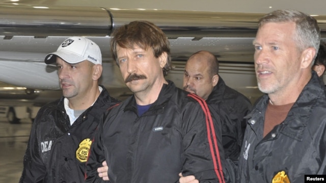 Convicted Russian arms dealer Viktor Bout (center) is escorted by U.S. Drug Enforcement Administration officers after arriving in the United States following his extradition from Thailand last year. 
