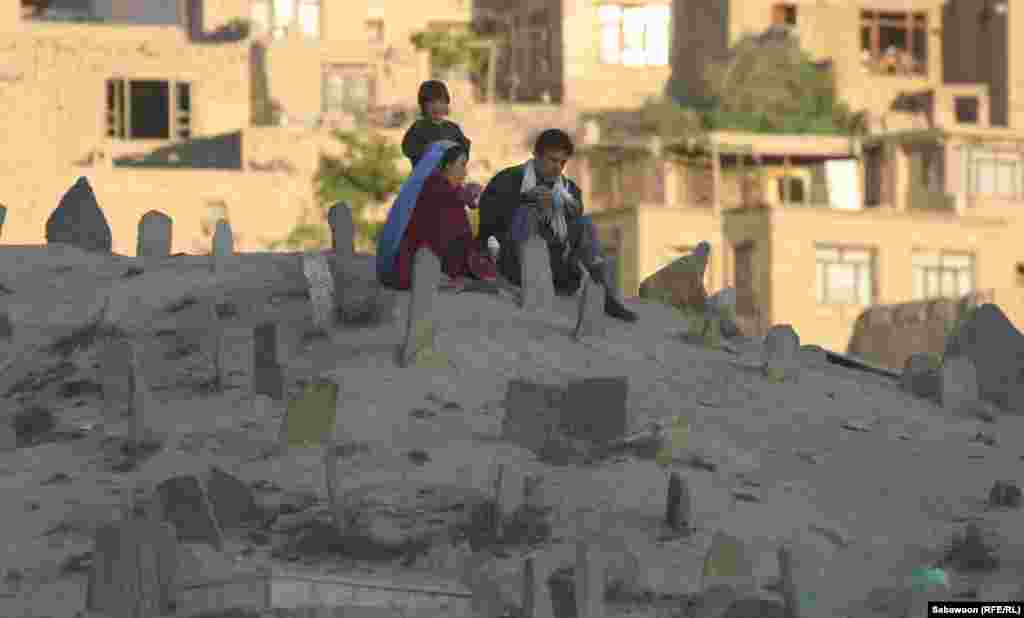 A family sits in a cemetery in Kabul.