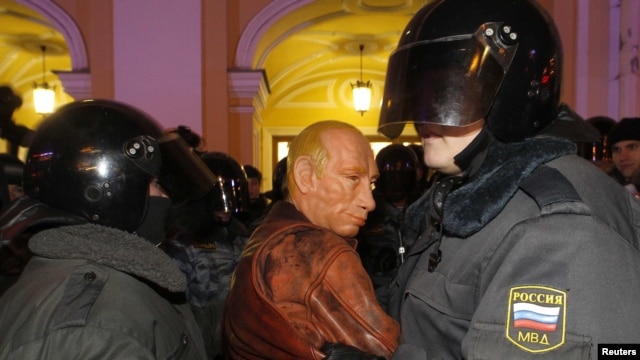 Police detain an activist wearing a Vladimir Putin mask during an opposition protest in St. Petersburg on December 8.