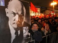 A Russian woman holding a portrait of Lenin during the traditional communist demonstration in downtown Moscow today (epa)