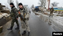 Ukrainian soldiers stand guard at a checkpoint on the outskirts of the town of Kostyantynivka in January.