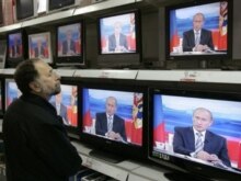 Russia – A Muscovite watches a televised question-and-answer call-in session with Russian President Vladimir Putin in Moscow, 18Oct2007