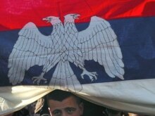 Kosovo -- A Kosovo Serb man covered with a Serbian flag looks on during a protest rally against proclaimed Kosovo's independence in Mitrovica, 18Feb2008