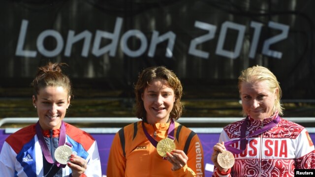 Cycling gold medalist Marianne Vos of the Netherlands (center) poses alongside silver-medalist Elizabeth Armitstead of Britain and bronze-medalist Olga Zabelinskaya of Russia.